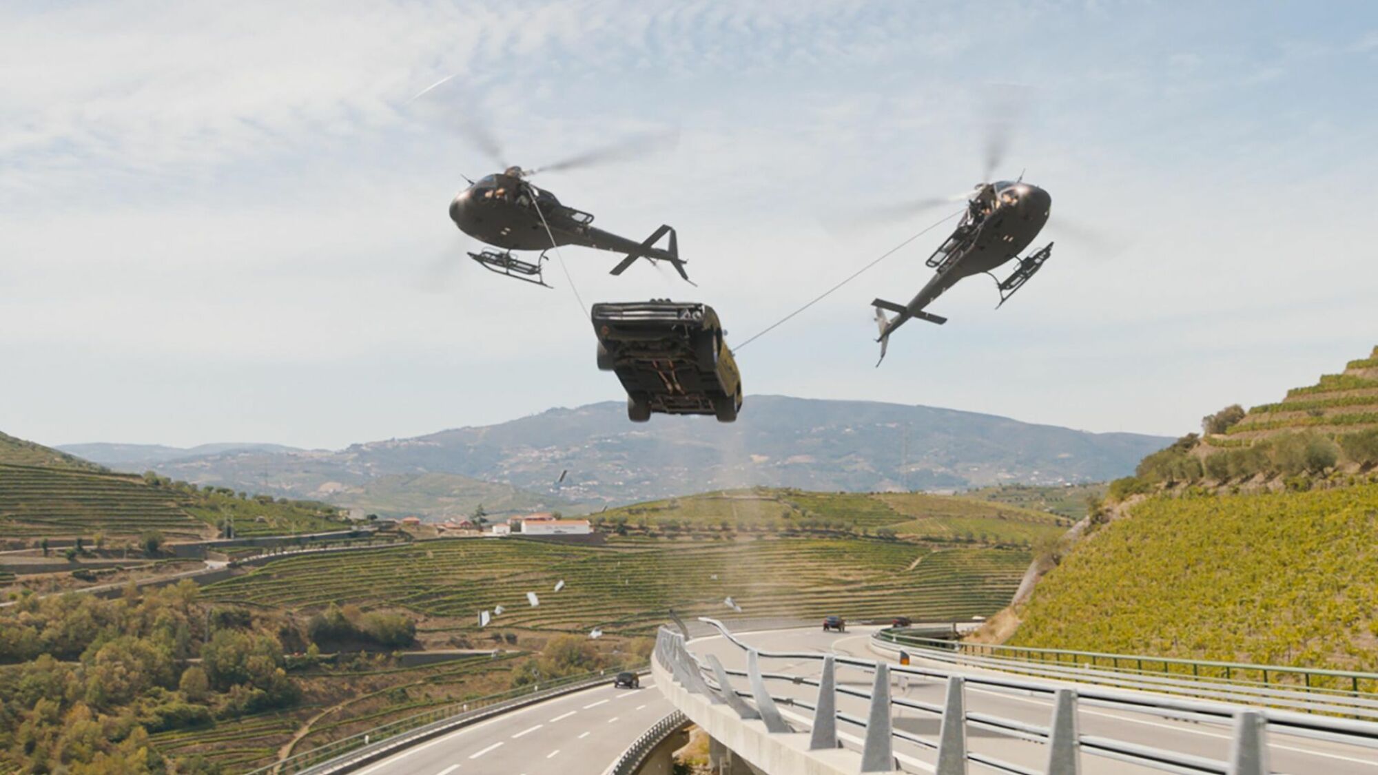 Two helicopters drag a car through the air in "Fast X."