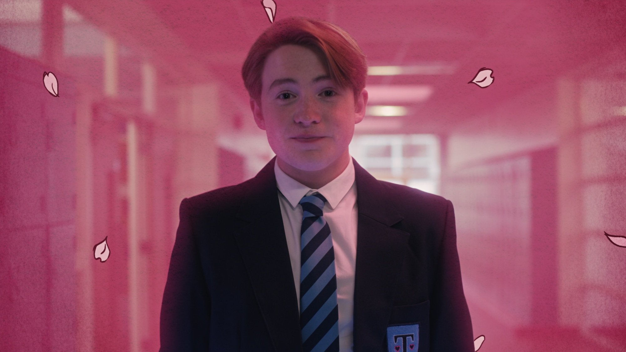 A teenage boy in a school uniform surrounded by pink light and cartoon petals.