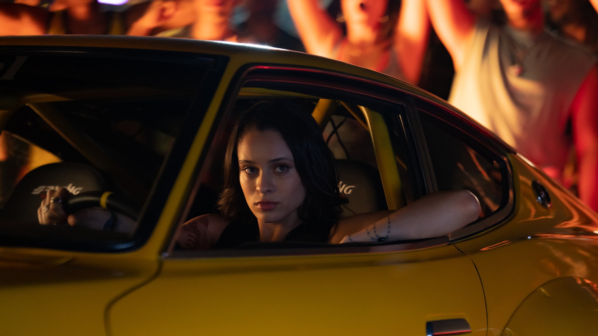 Daniela Melchior sits in a car surrounded by people in the film "Fast X."