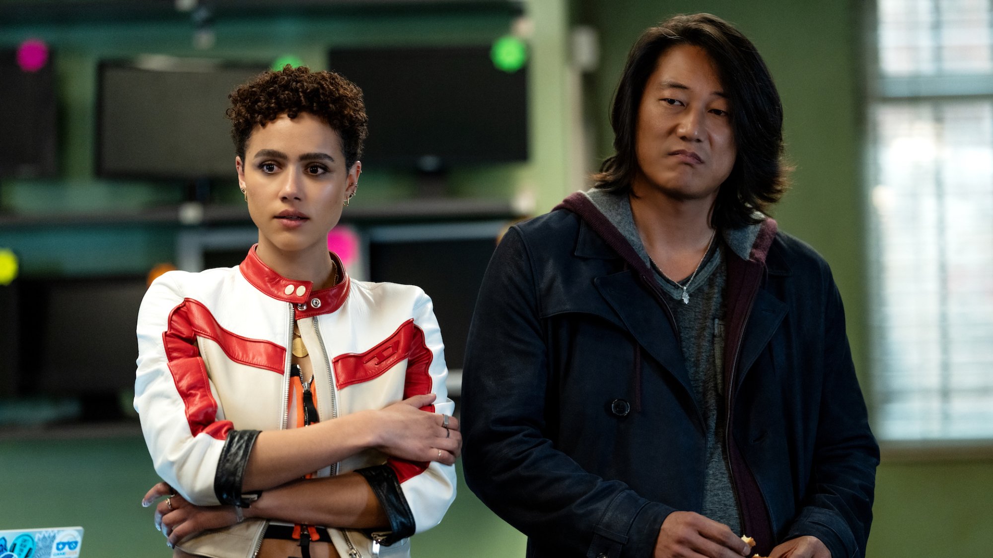 Nathalie Emmanuel and Sung Kang stand beside each other in a high-tech room in the film "Fast X."