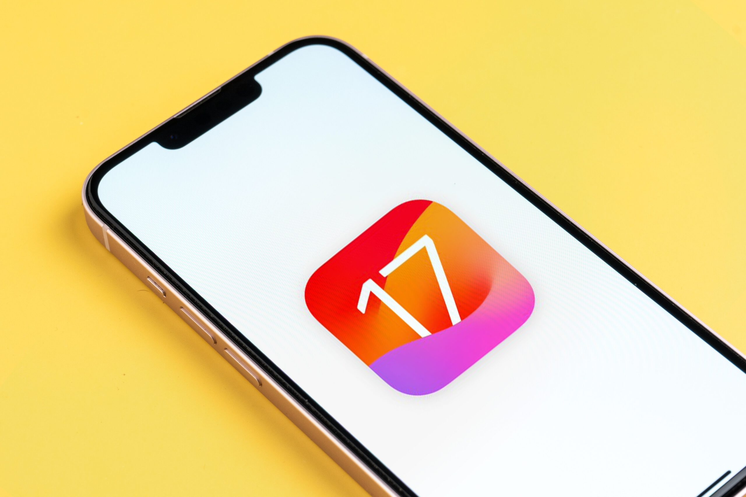 iOS 17 logo on an iPhone against a yellow background