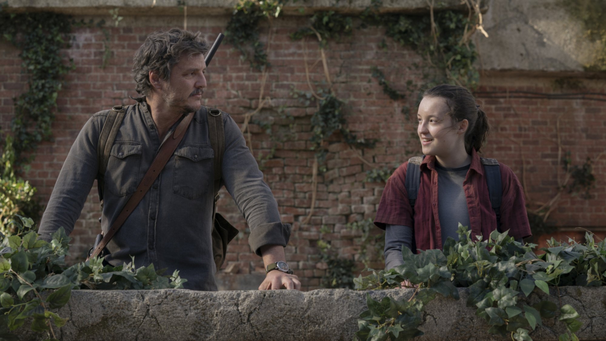 Pedro Pascal and Bella Ramsey look at each other in "The Last of Us." 