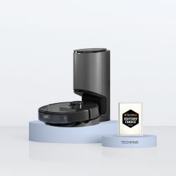 Black robot vacuum resting on dock and pedestal with a white rectangle to its right
