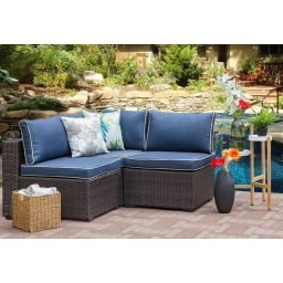 outdoor sectional with blue cushions poolside in a backyard 