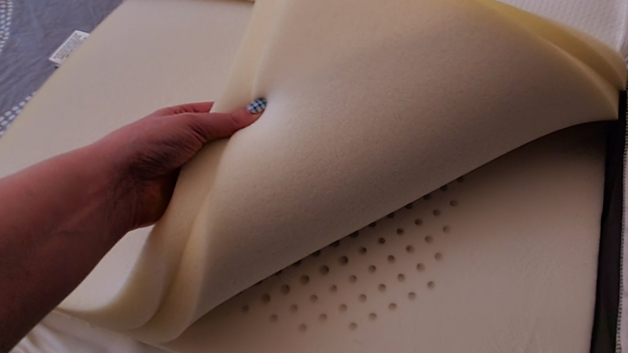 hand pulling back two foam layers of a pillow