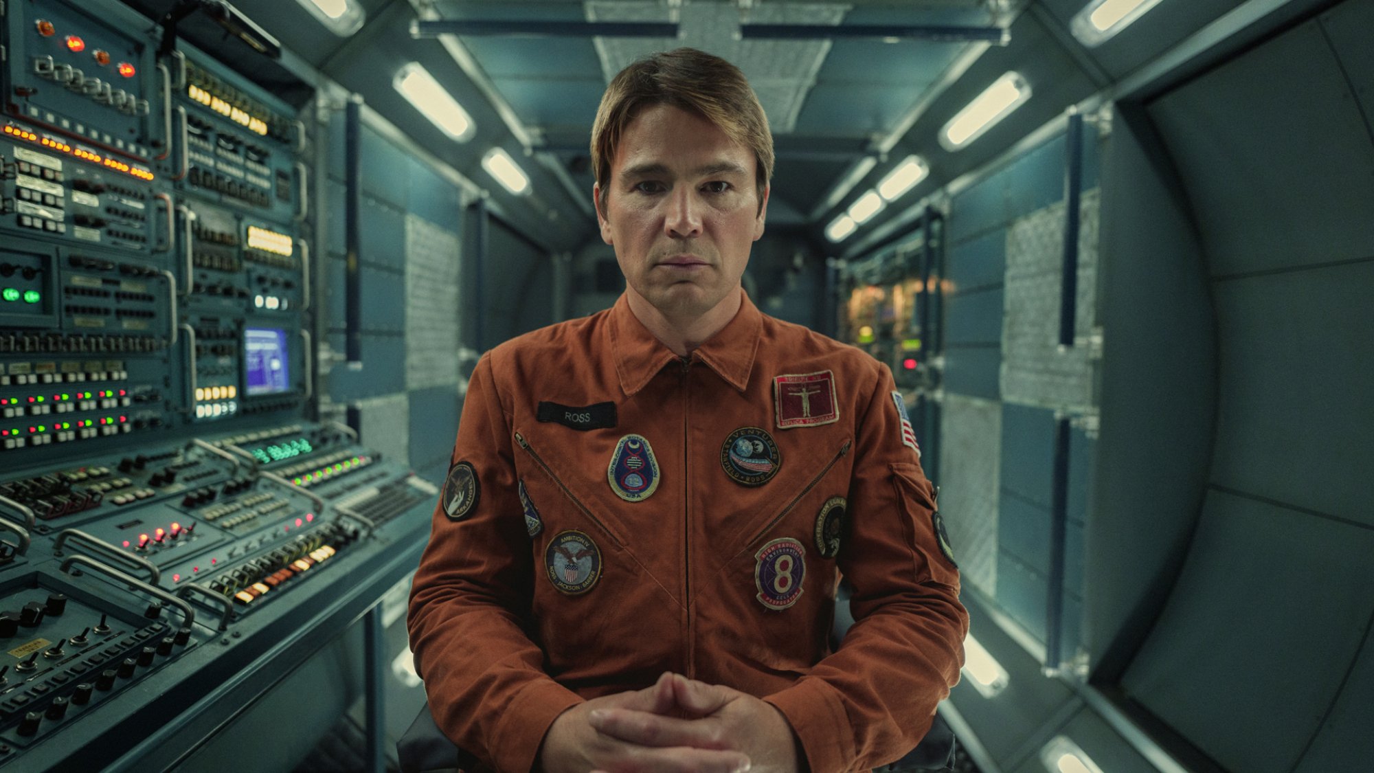 In the TV show "Black Mirror" Josh Hartnett is an astronaut sitting formally facing the camera in a space station.