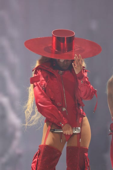 Beyoncé wearing a red fitted jumpsuit and broad brimmed hat at her Renaissance show in Amsterdam.