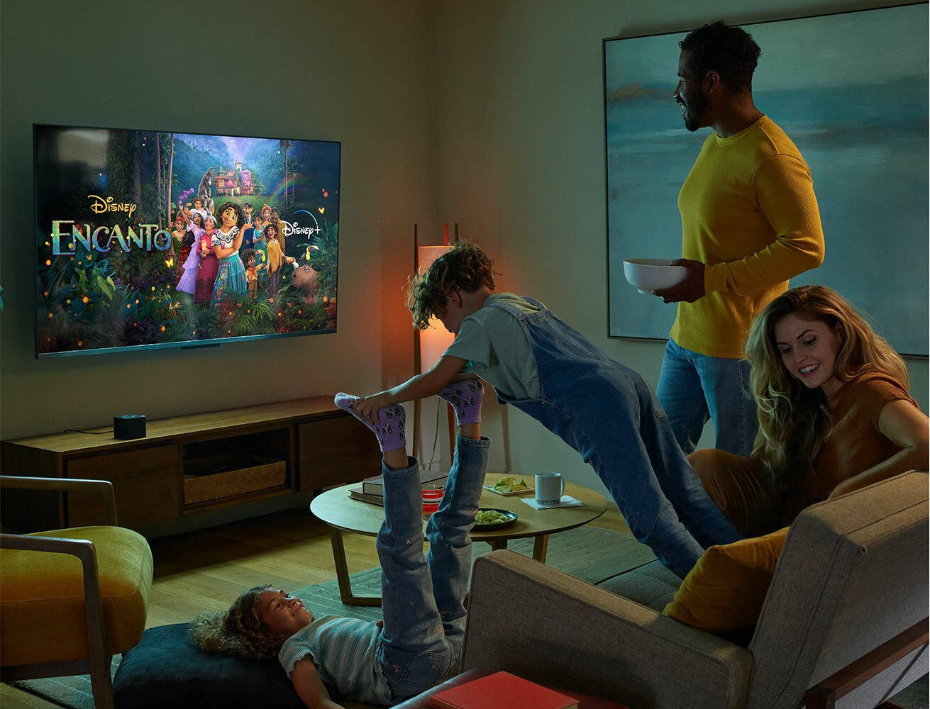 A family watching TV with a Fire TV Cube
