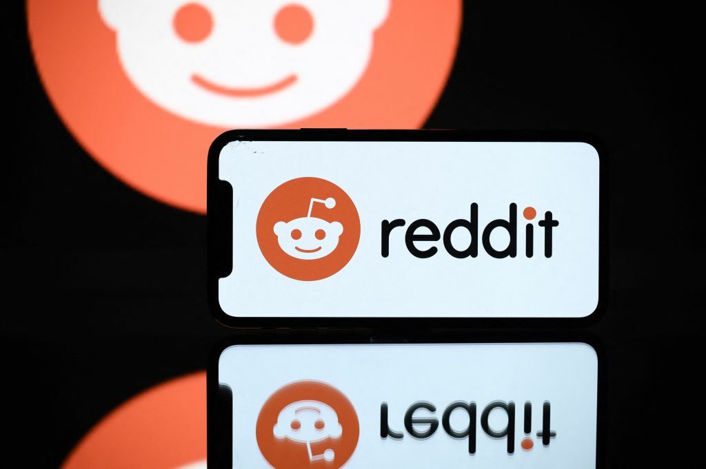 Reddit's logo displayed by a by a tablet and a smartphone.