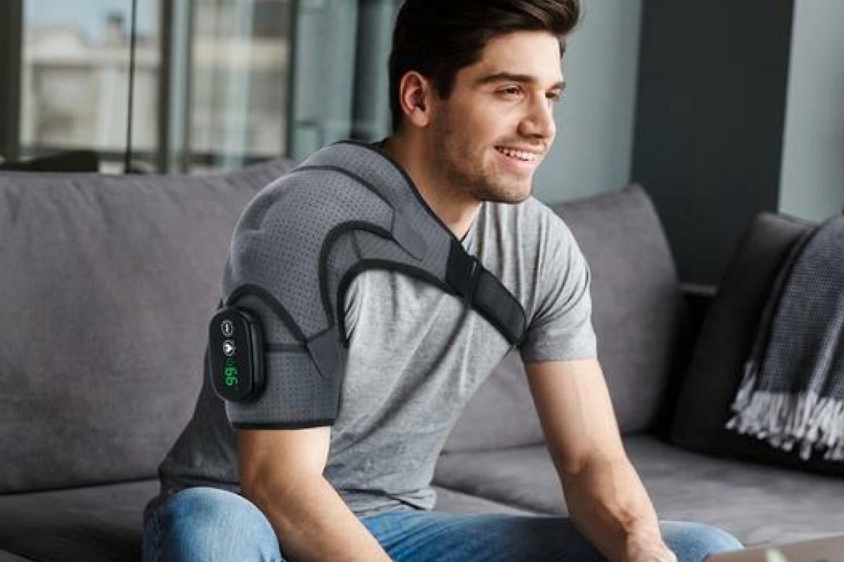 man on couch with shoulder massager on
