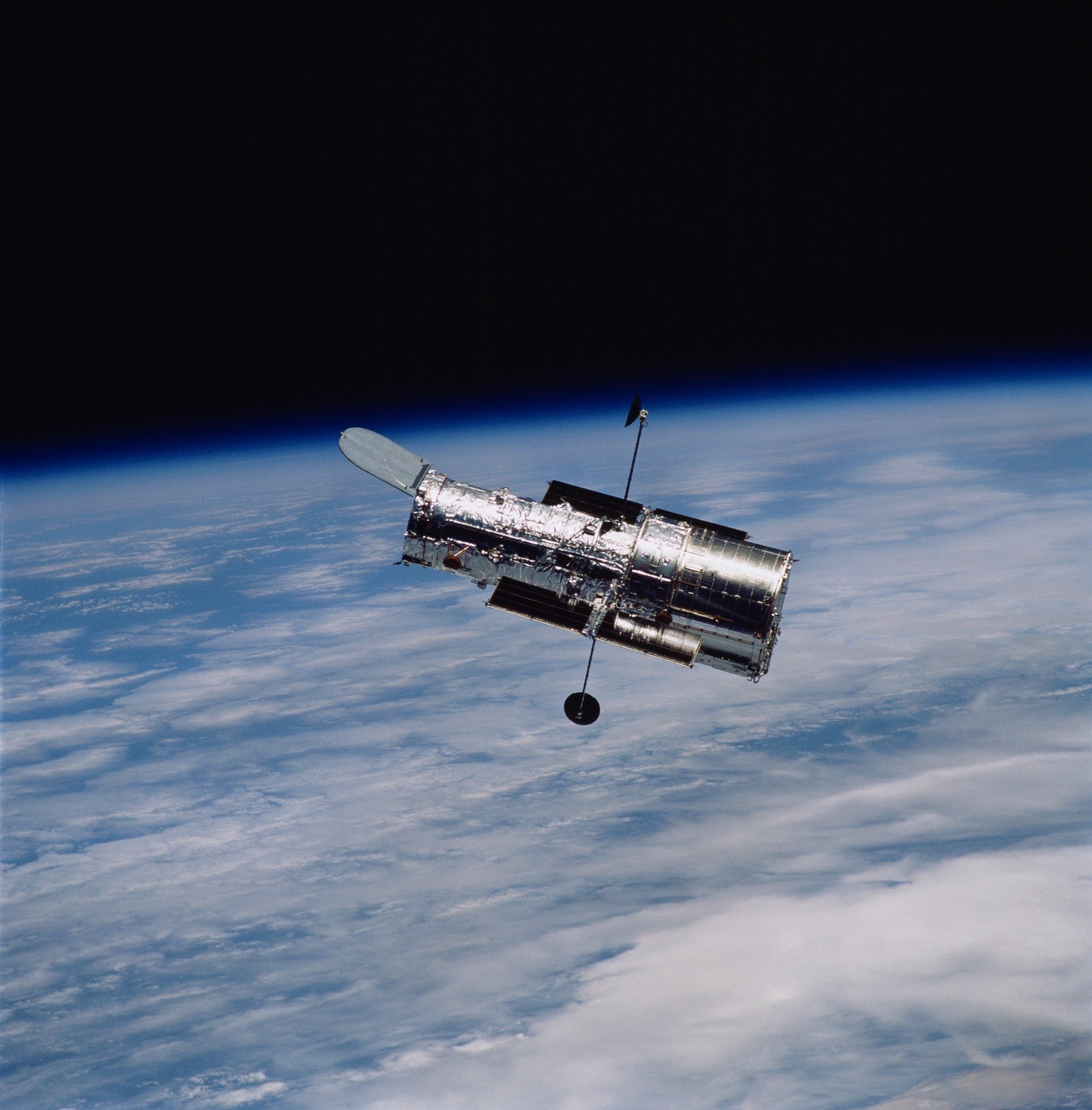The Hubble Space Telescope orbiting above Earth.