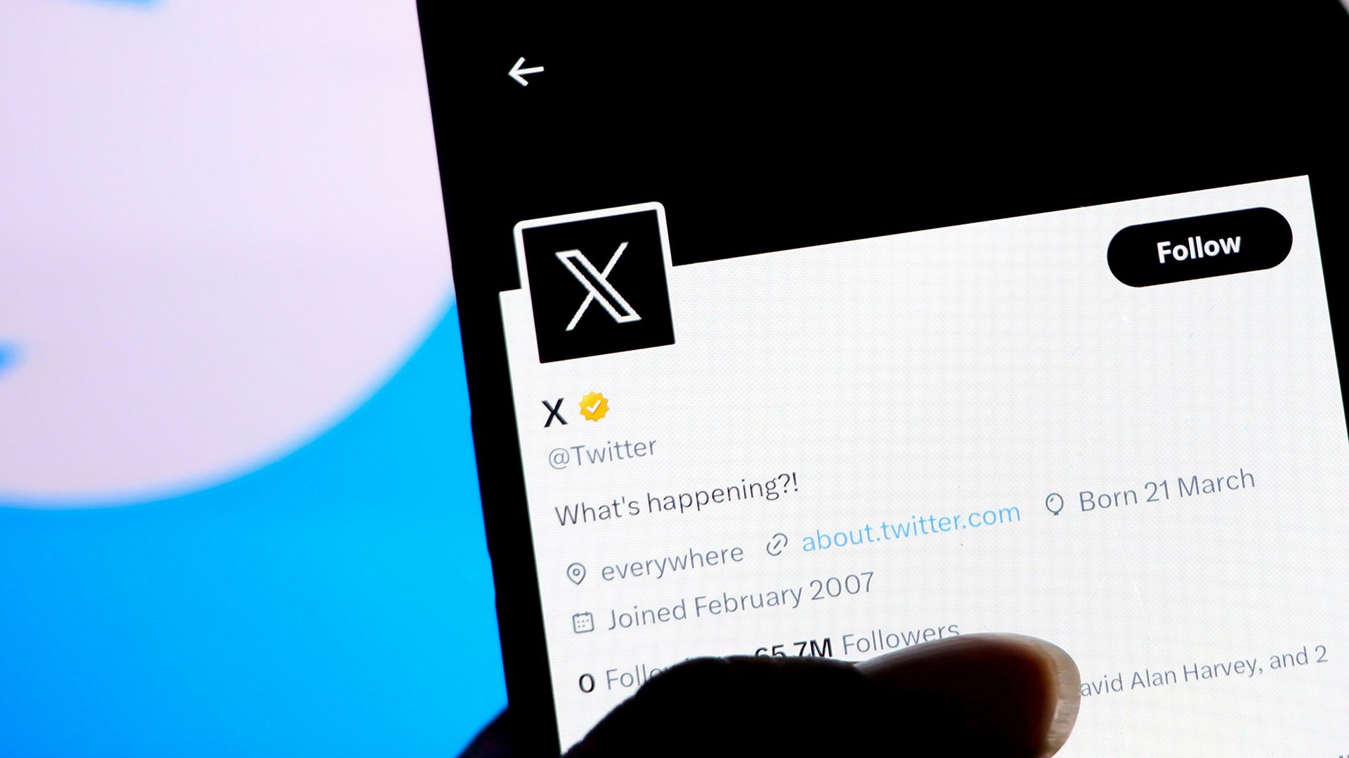 The X logo is visible on a smartphone.