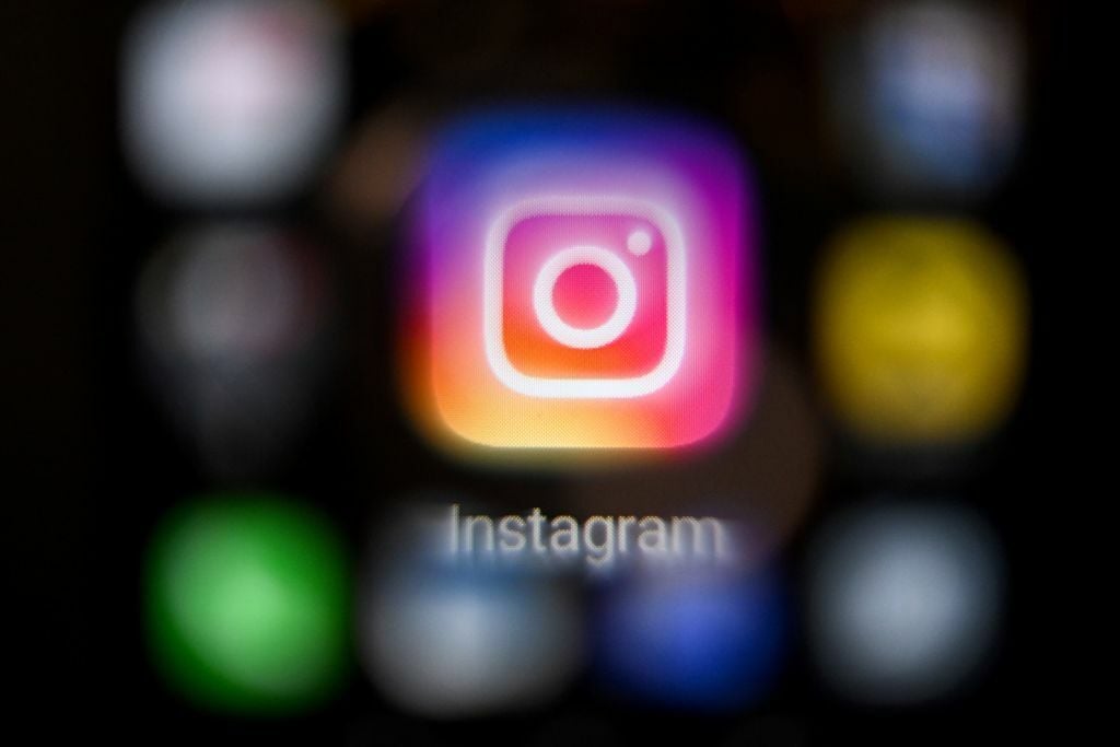 The Instagram app logo on a black blurred background