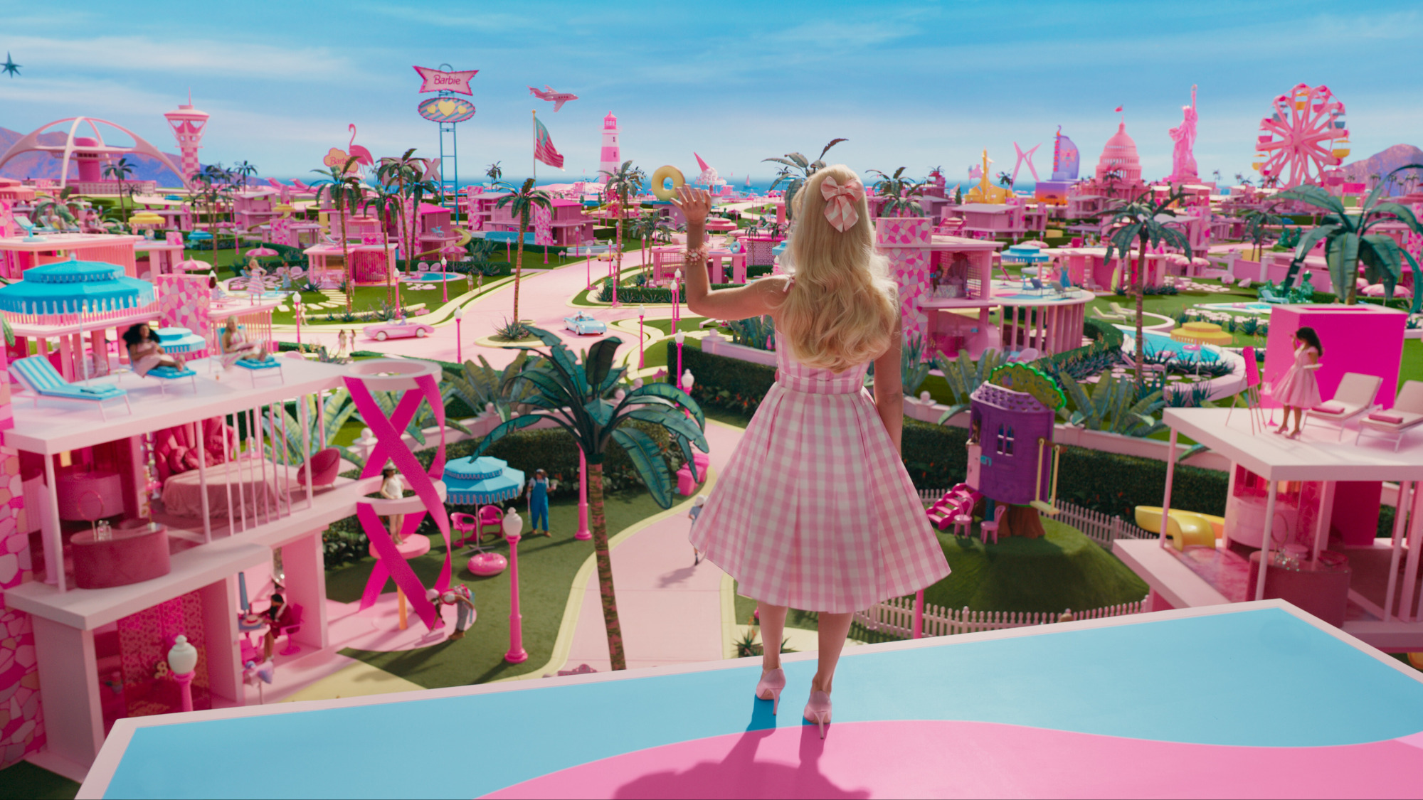 A woman wearing pink looks upon a pink toy land. 