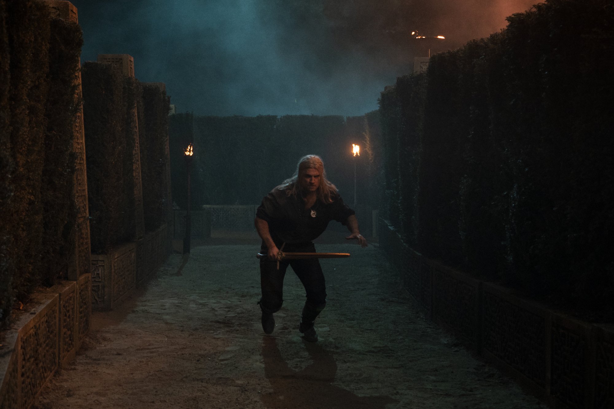 Henry Cavill as Geralt of Rivia, running through a maze in "The Witcher."