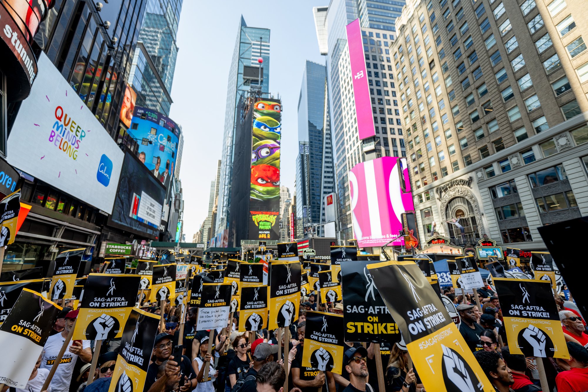 A large crowd of striking writers gather in the middle of Times Square.