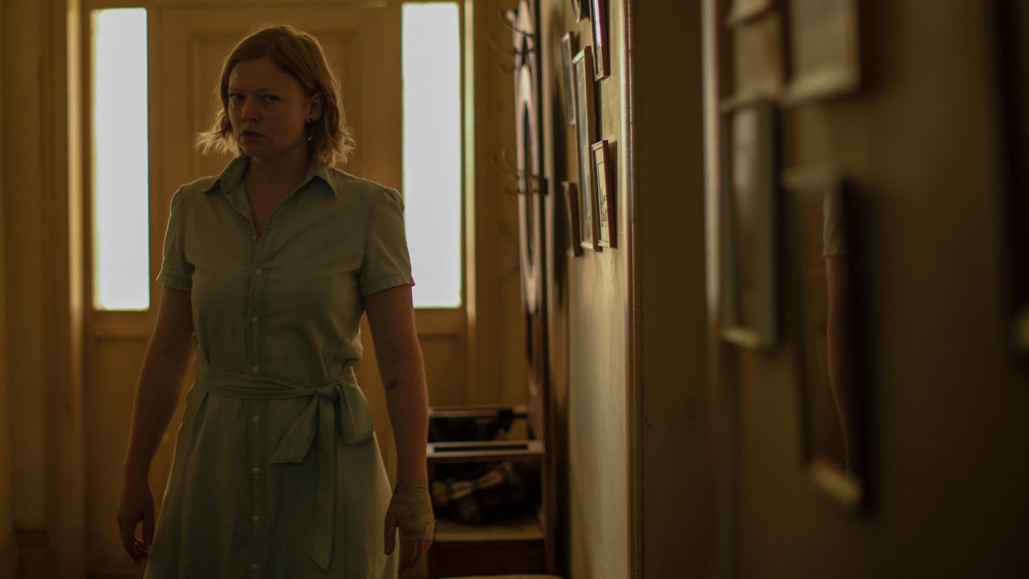 Sarah Snook walks through a dark house in the film "Run Rabbit Run"