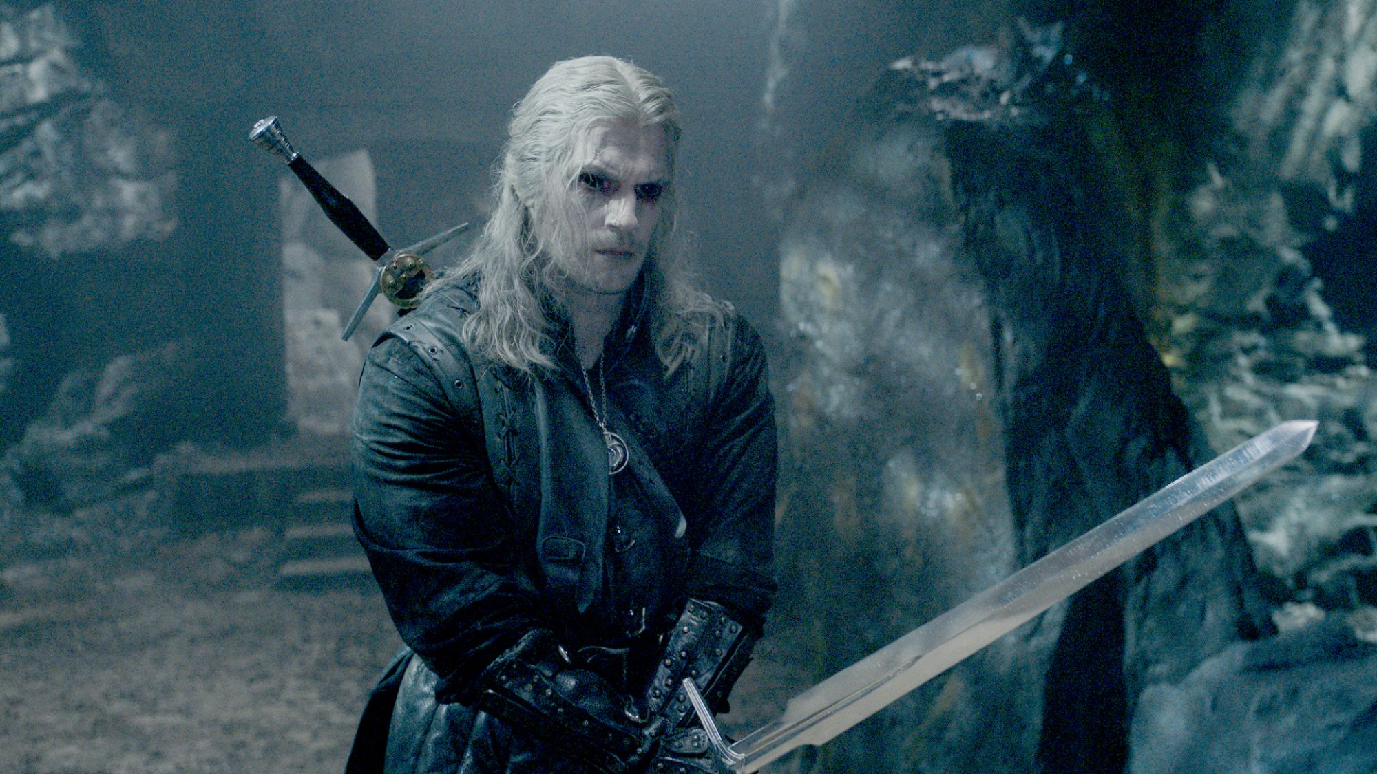 Henry Cavill in "The Witcher" as Geralt of Rivia, ready for combat.