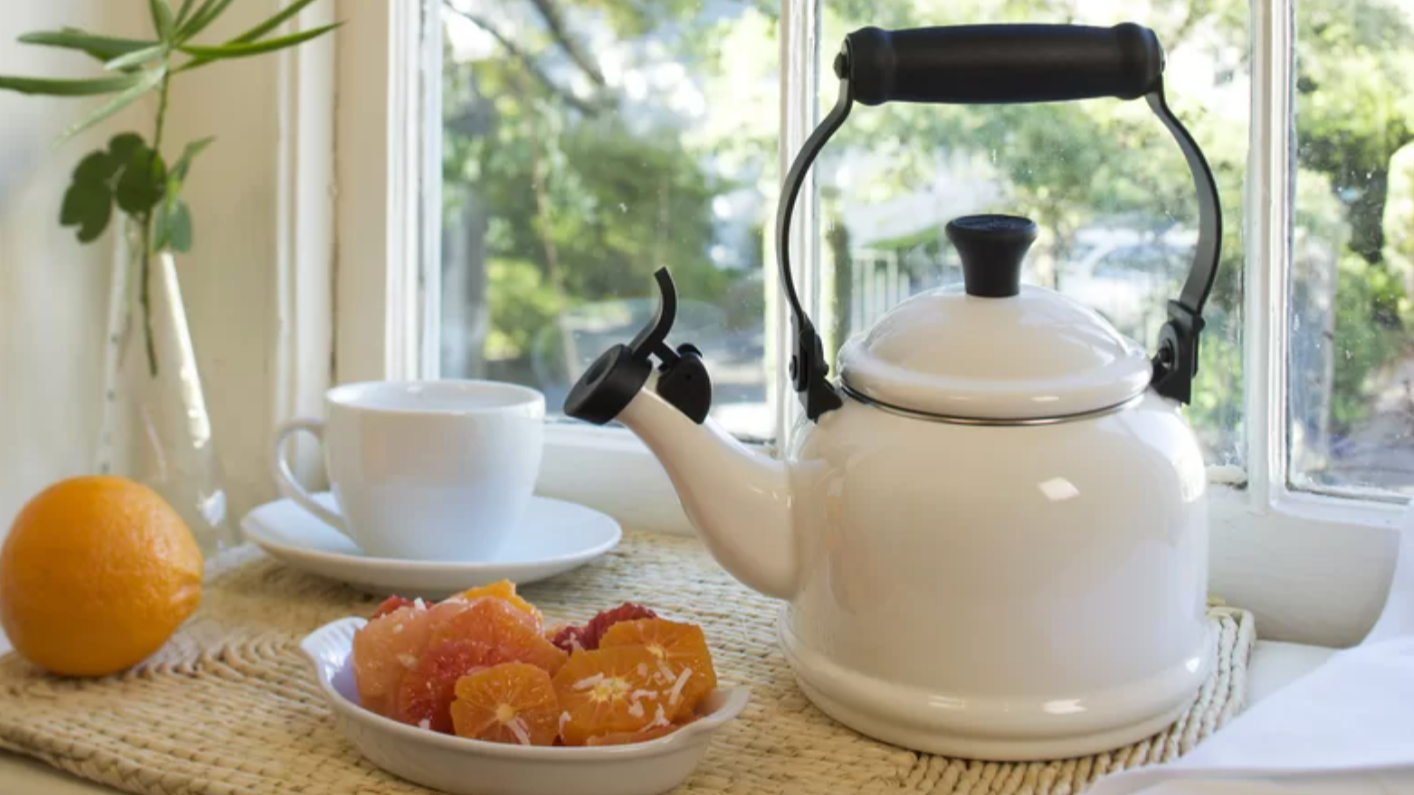 white Le Creuset tea kettle next to oranges