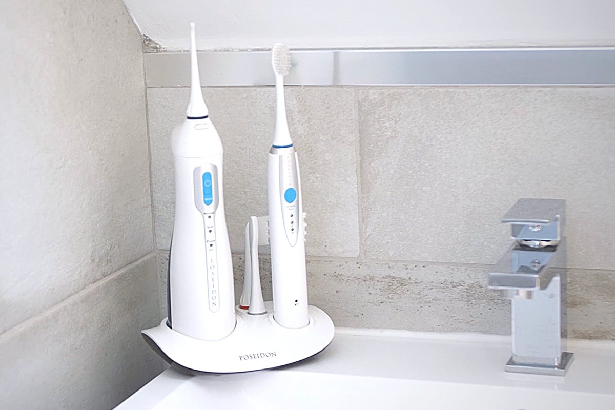 The electric toothbrush and water flosser set from Toiletree standing in someone's bathroom.