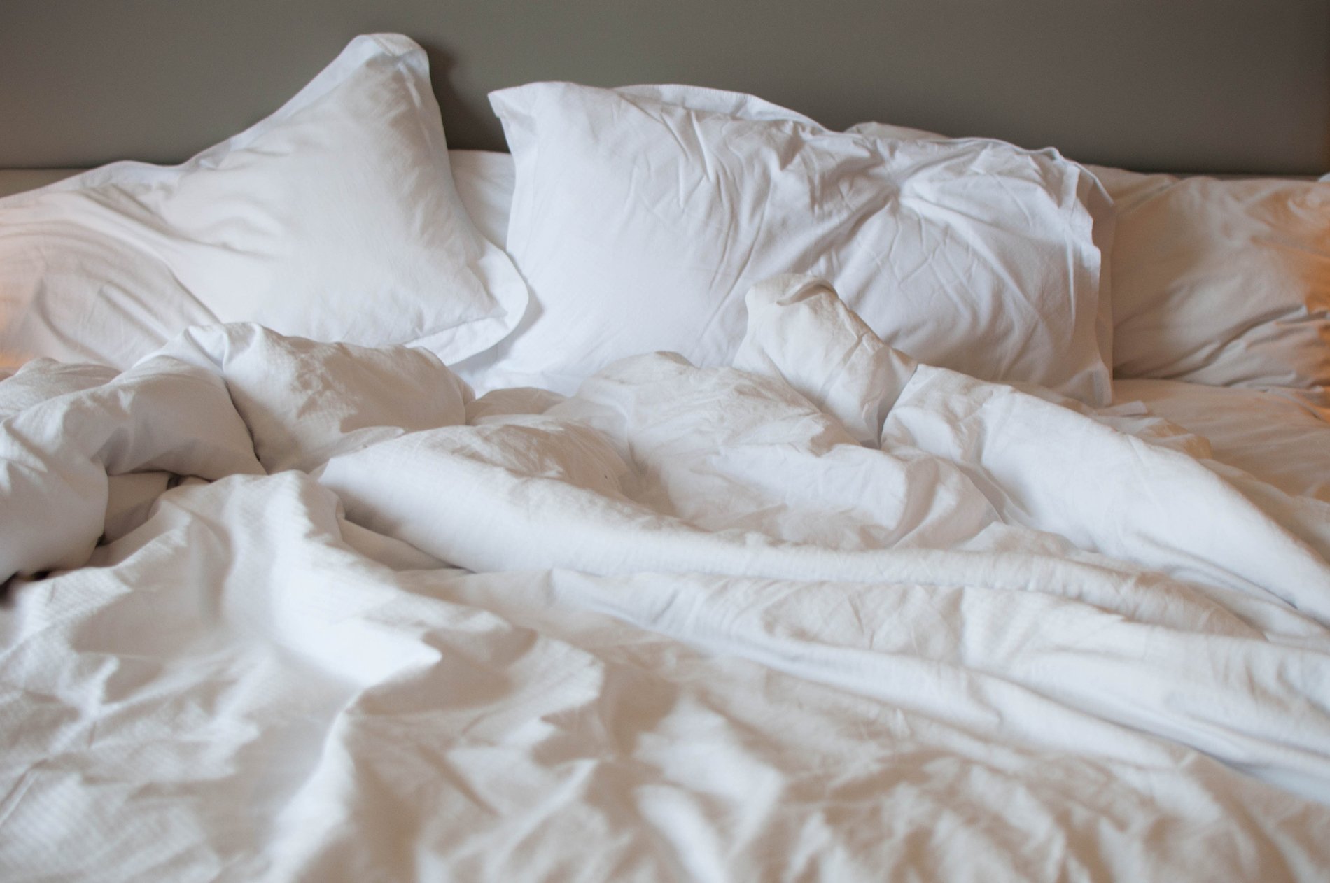 A close-up view of messy bed with comforter and pillows