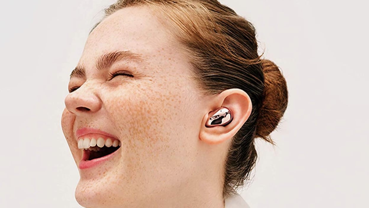 Woman with freckles smiling while wearing the Samsung Galaxy Buds Live in one ear.