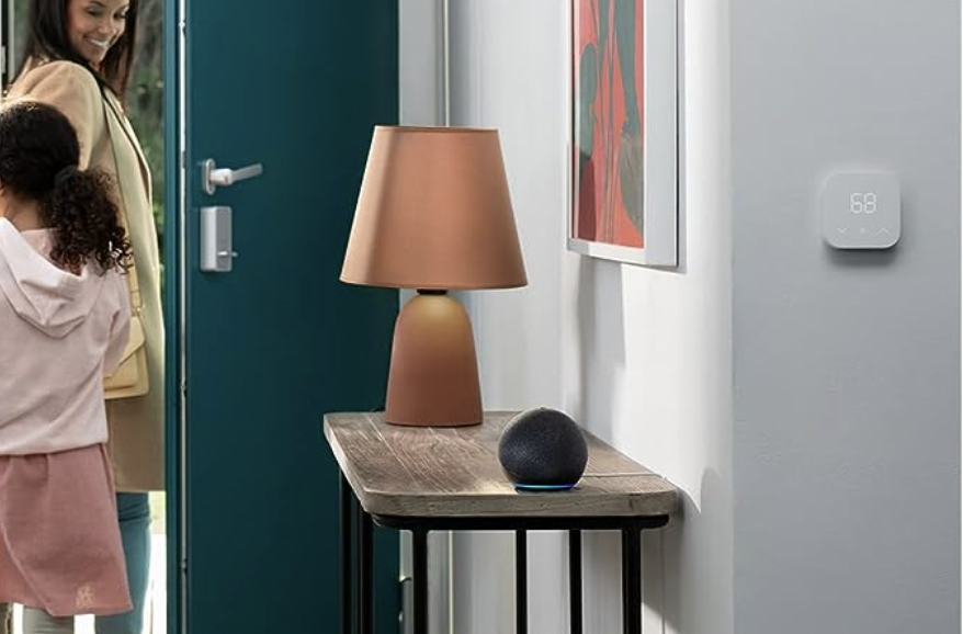 The Amazon Echo Dot resting on a table next to a lamp while a mother and daughter exit their house.