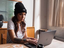 Girl in hat using iBrave Hosting on laptop