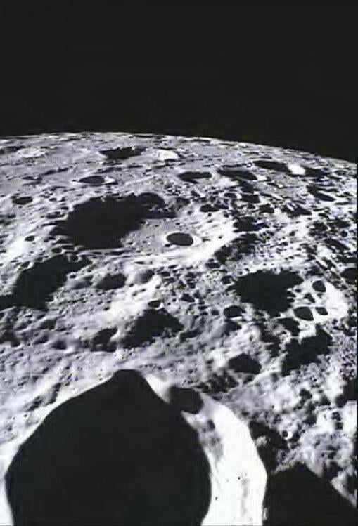 Spacecraft flying over lunar craters