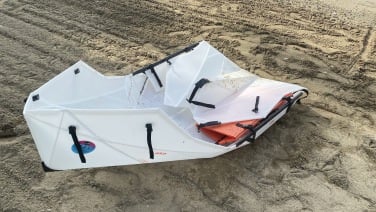 An unassembled, half folded Oru Lake kayak