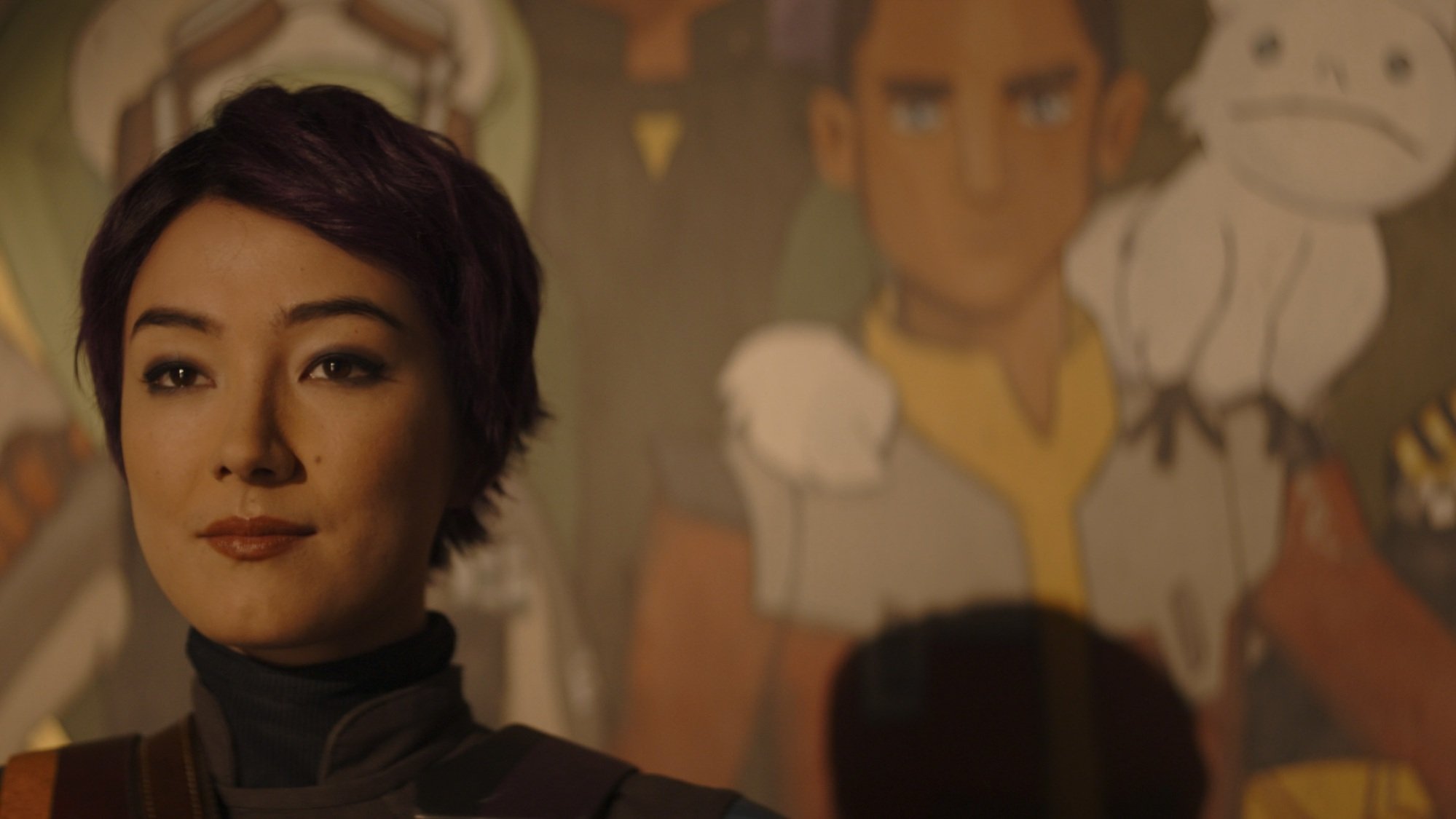 Sabine Wren stands in front of a mural of Ezra Bridger and other "Star Wars Rebels" characters.