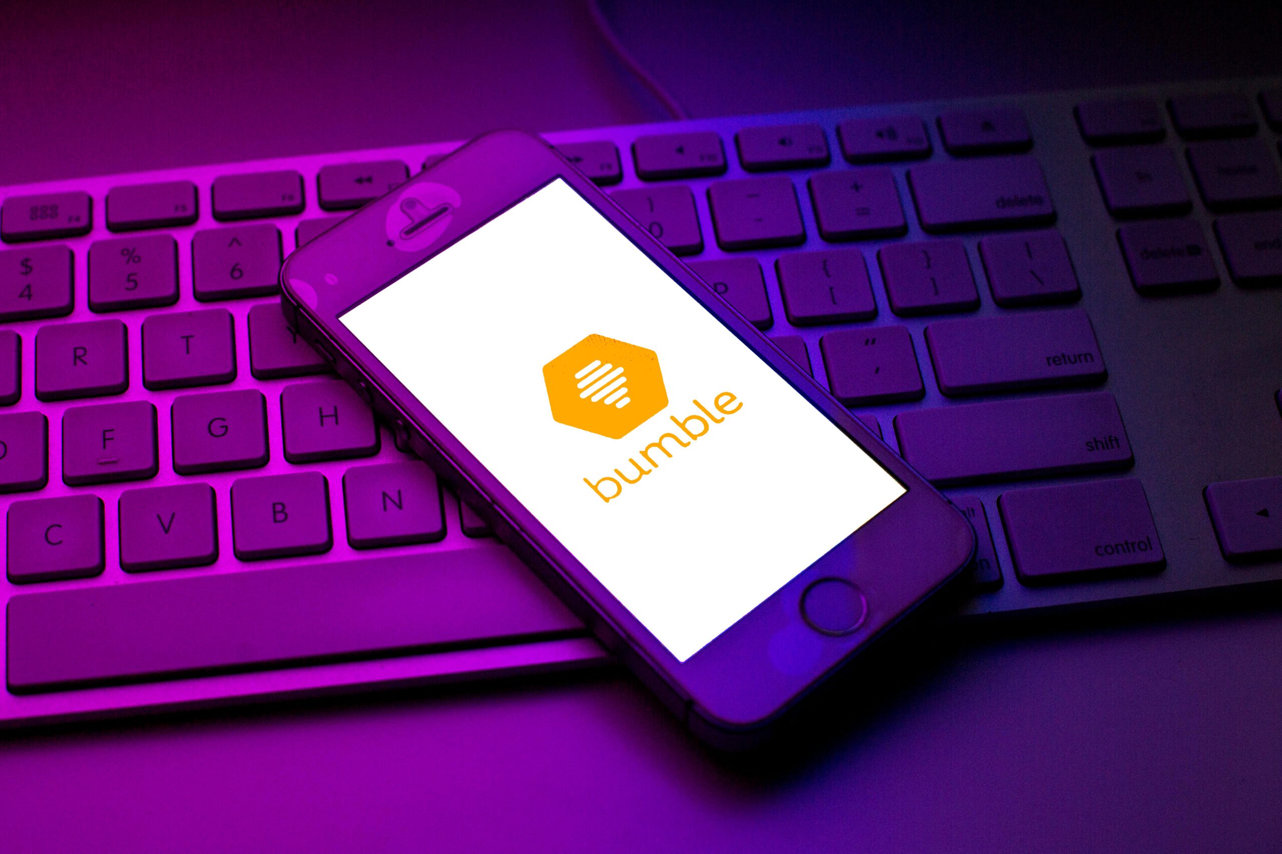 Bumble logo seen displayed on a smartphone on top of a computer keyboard