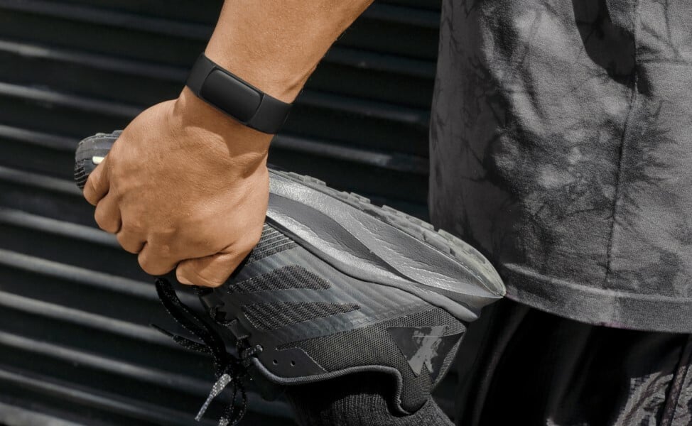 Man wears a Fitbit Charge 6 on wrist and stretches 