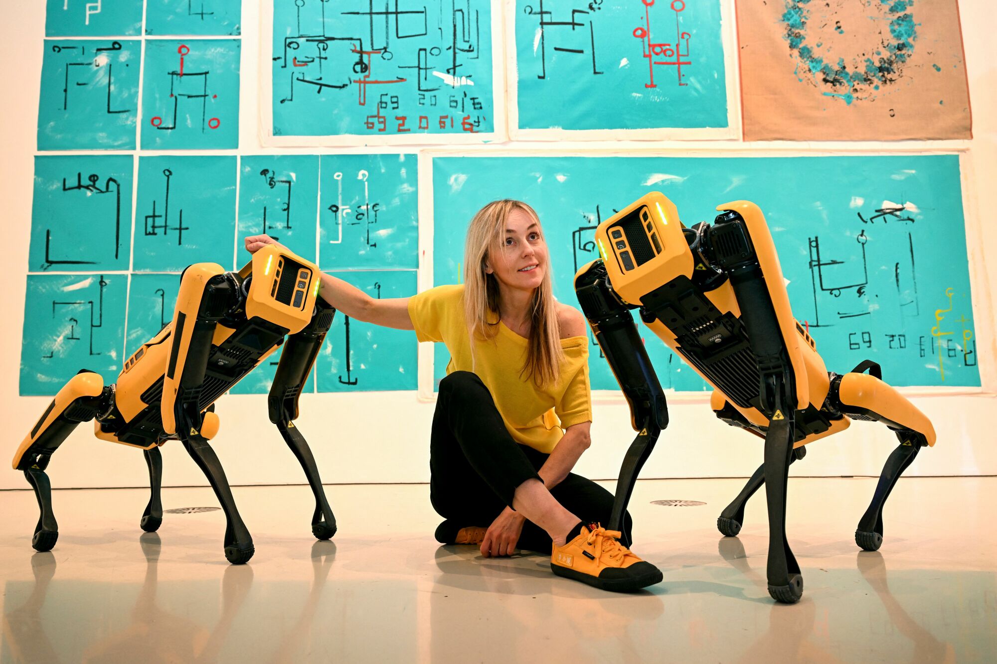 Agnieszka Pilat posing with robotic dogs