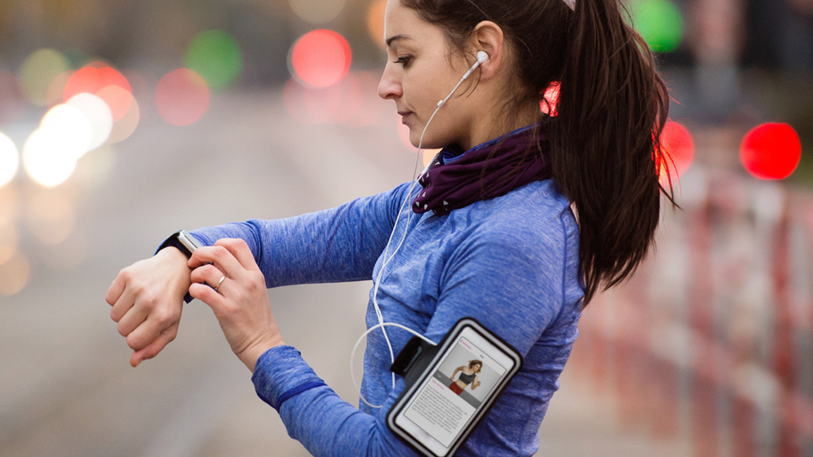 woman checking smartwatch on a run