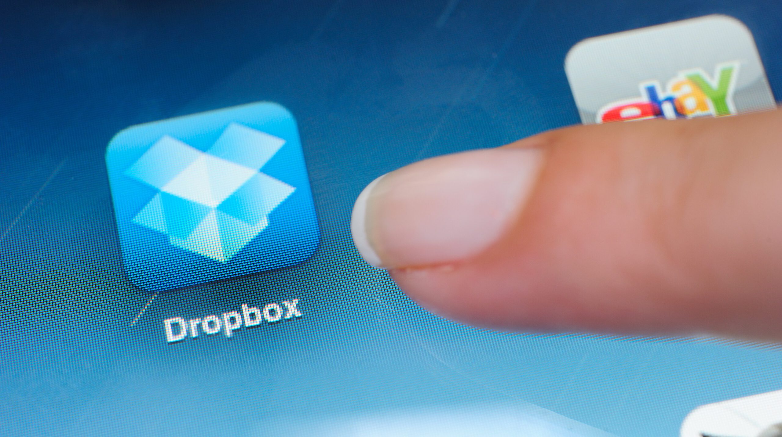 Macro image of touching the Dropbox icon on iPad screen. Dropbox is a Web-based file hosting service operated by Dropbo