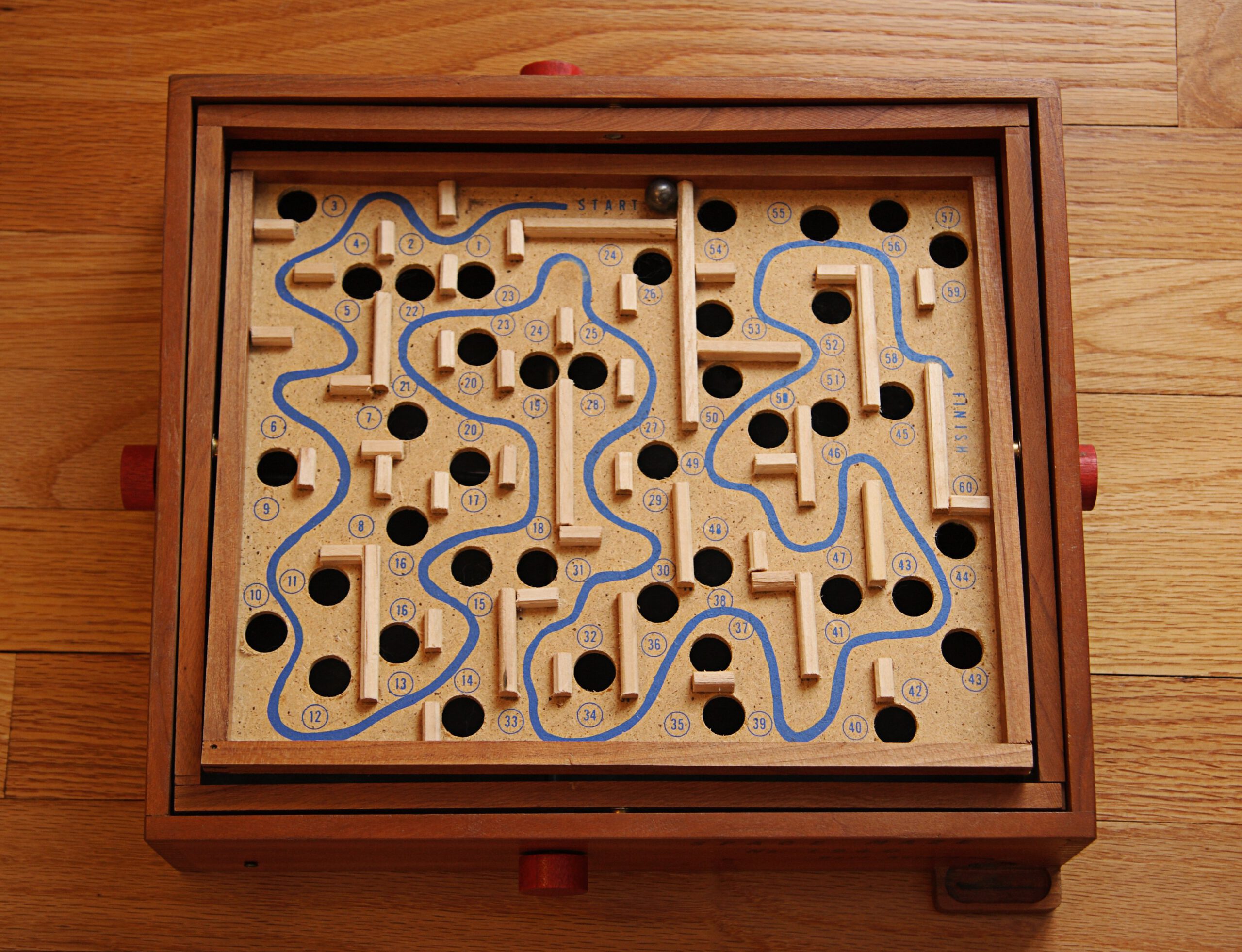 Labyrinth maze game that's a wooden box containing a tilting board on top and a marble 