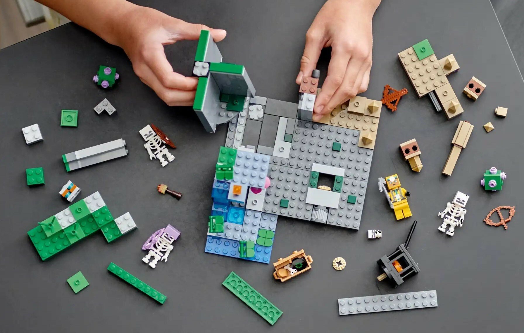 two child's hands play with a Minecraft set of Legos