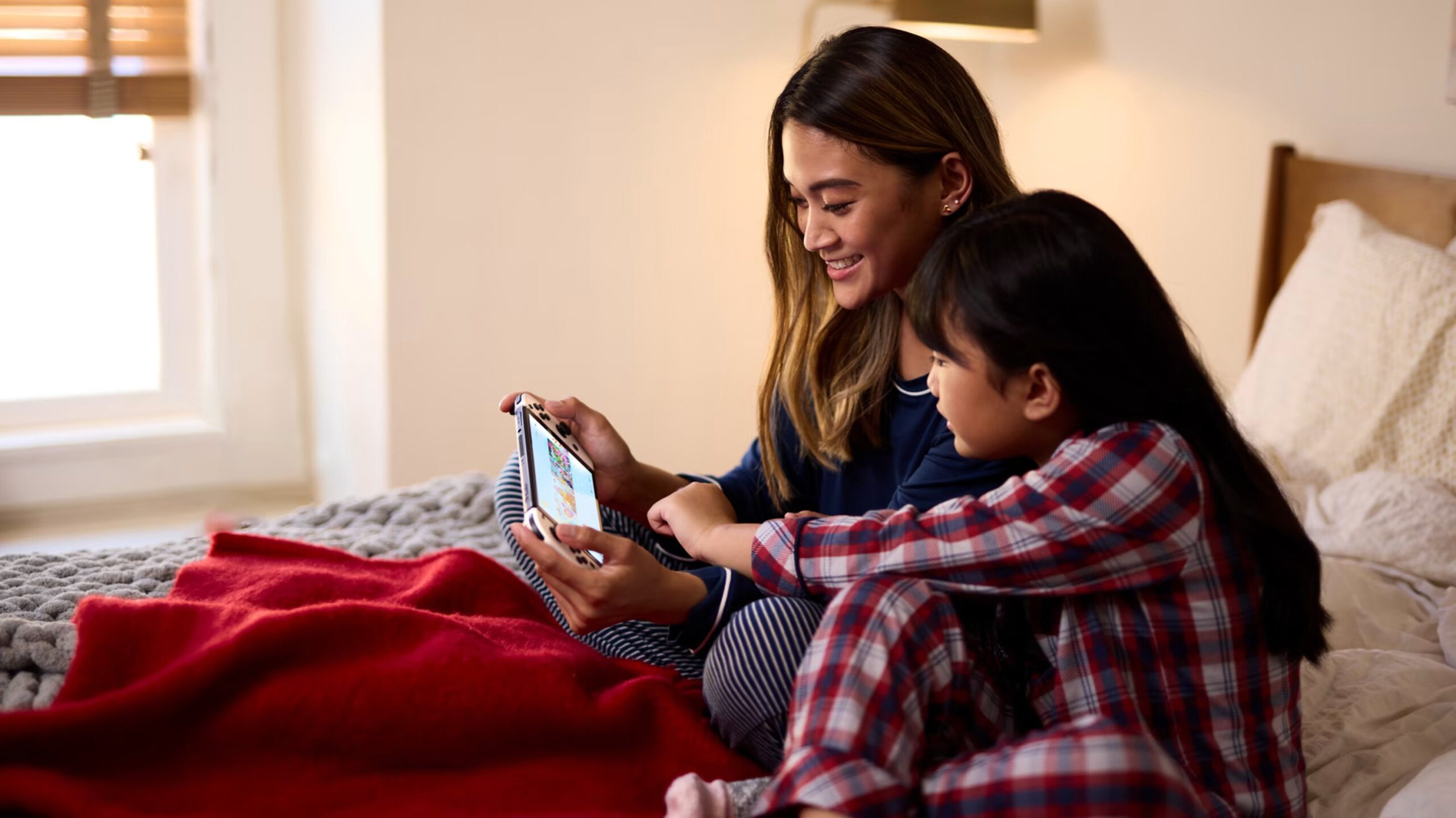 A young woman and child play the nintendo switch together