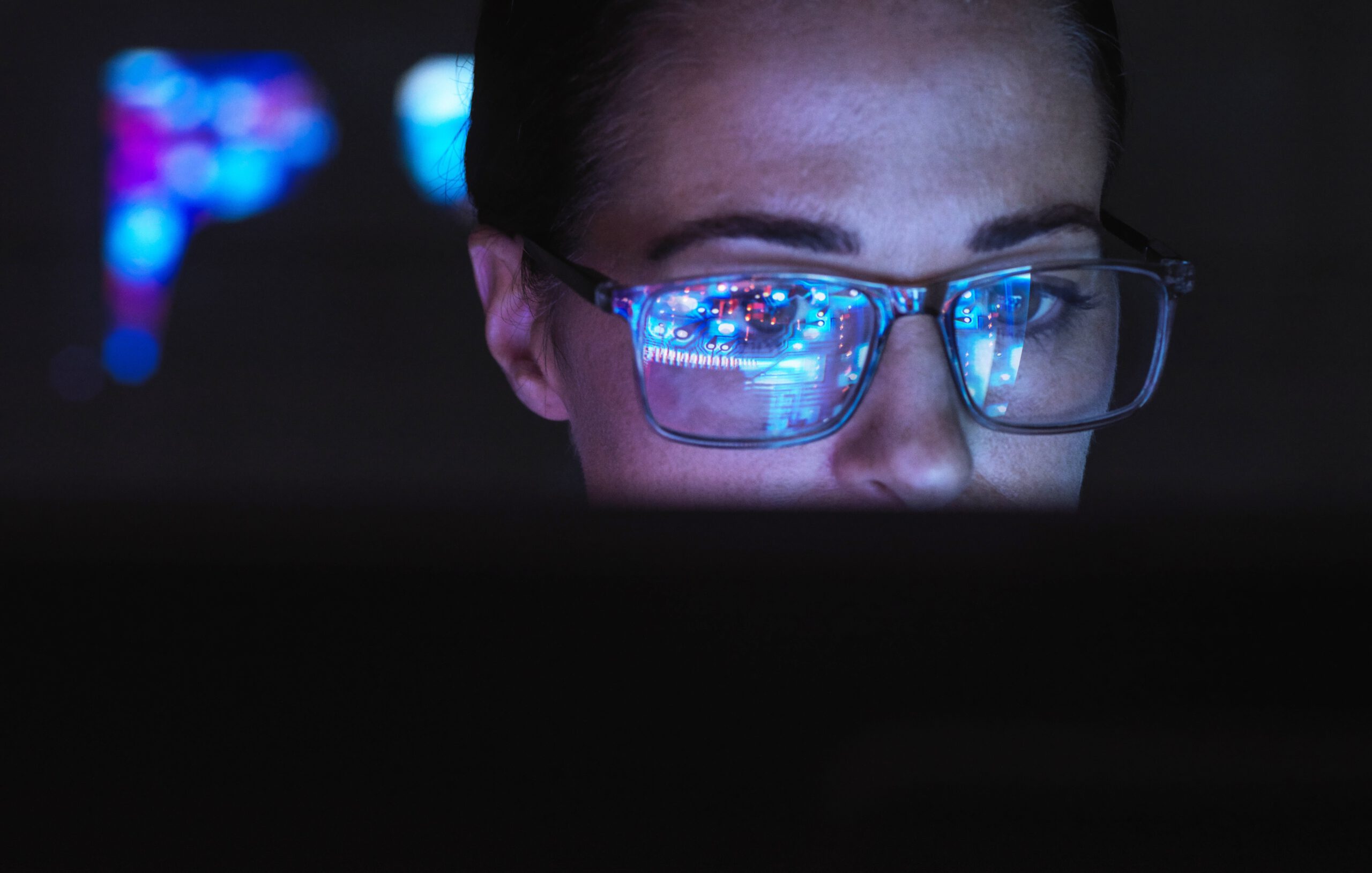 woman working on computer with AI tech reflection in glasses