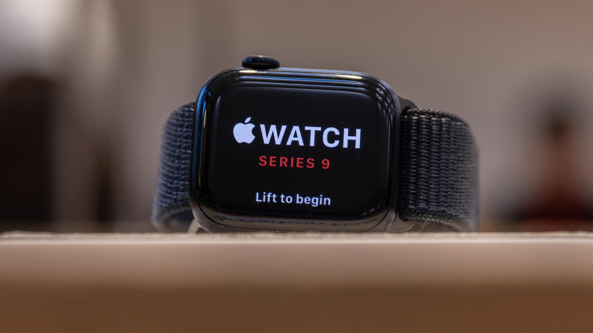 An Apple Watch Series 9 is visible on a stand.