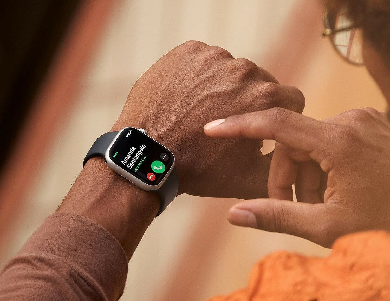 a person looks at their left wrist which is wearing an apple watch series 8 smart watch