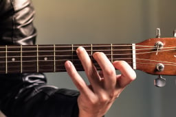 close up of person playing guitar