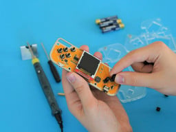 A close up of person's hands working on the Nibble DIY console
