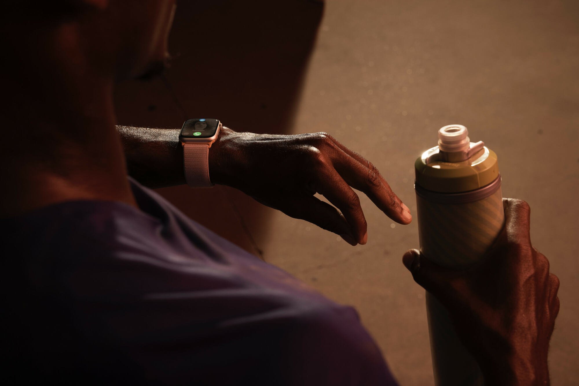 Apple Watch Series 9 on man's wrist as he double taps with a drink in his other hand