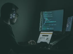 person coding in the dark
