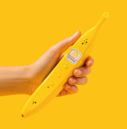 A Caucasian hand holding a phone in the shape of a banana.