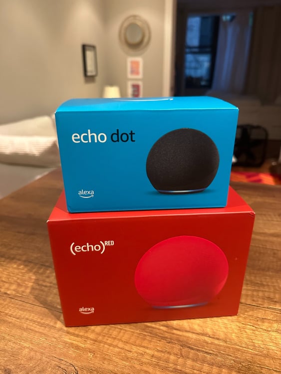 The Echo Dot and Echo smart speaker packages stacked on top of each other.