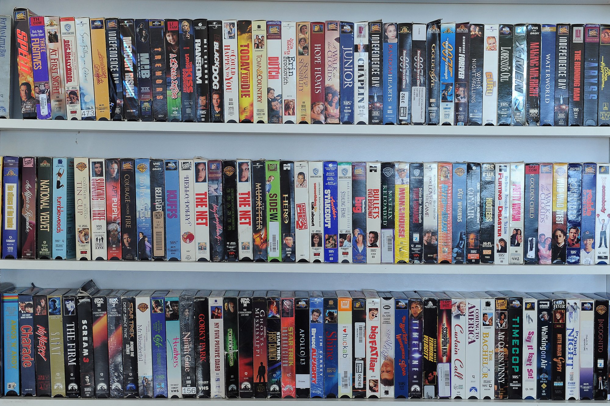 Three shelves of VHS tapes.