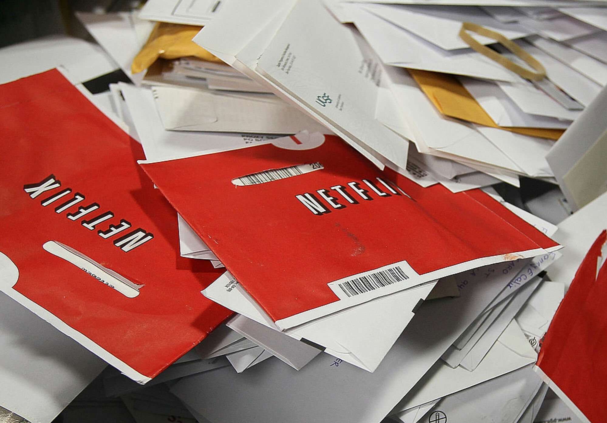 red Netflix DVD envelopes in a pile of mail